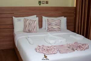 ein Bett mit weißen Laken und Handtüchern in der Unterkunft Cicada Hotel in Eldoret + 17 Fotos