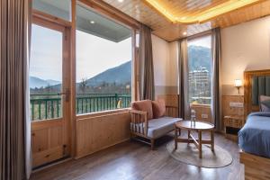 a bedroom with a bed and a window with a view at The Trippy Tribe Manali in Manāli