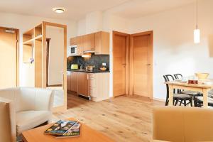 ein Wohnzimmer und eine Küche mit einem Tisch und Stühlen in der Unterkunft Apart Arga Top in Serfaus