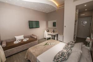 salon z 2 łóżkami i kanapą w obiekcie Elenoire Rooms & Suite w Rzymie