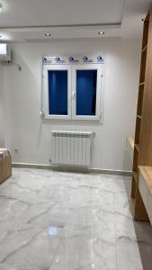 a room with a large marble floor and two windows at Grand studio tout équipé in Ben Mered