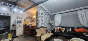 a living room with a black couch and a brick wall at Abi se Nessie in Orania
