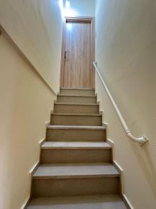 a stairway with a wooden door and a stair case at Volakis apartments in Chios