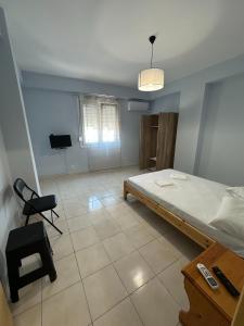 a bedroom with a bed and a chair in it at Volakis apartments in Chios