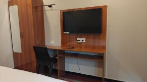 a room with a desk with a tv and a chair at Hotel Sivani in Kalakkādu +8 photos