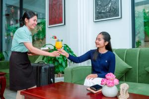 a woman holding up a glass ofasteryasteryasteryasteryasteryasteryasteryasteryastery at Homewood Hotel Siem Reap in Siem Reap