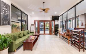 a living room with a green couch and tables at Homewood Hotel Siem Reap in Siem Reap +140 photos