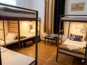 ein Zimmer mit drei Etagenbetten und einem Tisch in der Unterkunft Hotel Olive Tree in Agra