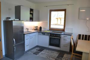 a kitchen with a stainless steel refrigerator and a window at Ferienwohnung Pusteblume4 in Oberau +13 photos