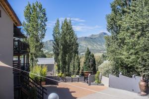 a backyard with trees and mountains in the background at High on a Hill in Clarens