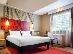 a bedroom with a large bed and a window at Hotel Ibis Krakow Centrum in Krakow