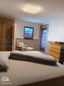 a bedroom with a bed and a chair and a window at Ferienwohnung Pusteblume4 in Oberau