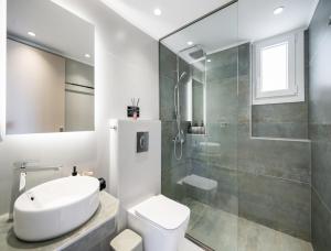 a bathroom with a shower and a toilet and a sink at Asmira Apartments in Lygia +16 photos