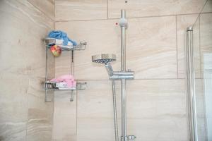 a shower with four shelves in a bathroom at House in Manchester MVS Snug Urban Hideaway in Manchester +51 photos