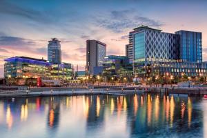 a city skyline with tall buildings and a body of water at House in Manchester MVS Snug Urban Hideaway in Manchester