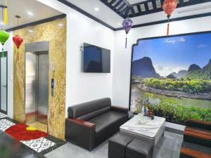 a living room with a couch and a large screen at Khách Sạn Phố Cổ Ninh Bình NANA HOTEL in Kỳ Vĩ