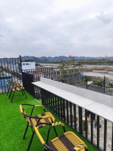 two chairs and a table on a balcony with grass at Khách Sạn Phố Cổ Ninh Bình NANA HOTEL in Kỳ Vĩ