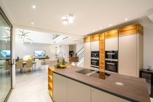 a kitchen with white cabinets and a dining room at Luxury Seafront Villa Miracul Korcula with Pool in Blato