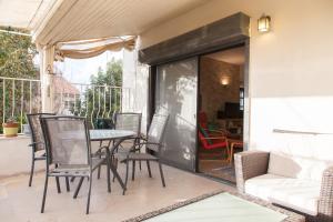 a patio with a table and chairs and a couch at Carmel Home Mount Seaview in Haifa