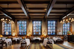 a dining room with tables and chairs and windows at Grand Hotel Terminus in Bergen