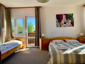a bedroom with two beds and a balcony at Aqualand Penzion - free parking in Poprad +47 photos