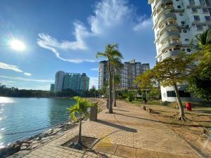 a sidewalk next to a body of water with buildings at BayView Suites Port Dickson By MAISON in Port Dickson