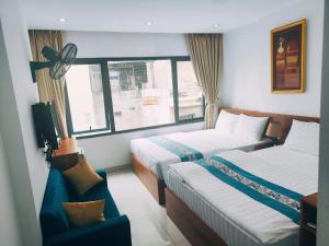 a hotel room with two beds and a window at okaeri hotel in Hanoi