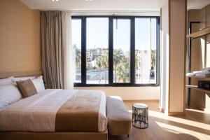a bedroom with a large bed and a large window at Koral Boutique Hotel in Durrës +33 photos