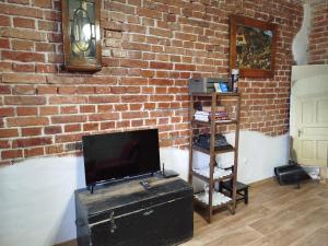 a living room with a brick wall with a tv and a trunk at Rodinný dom Cavern - Rajec, 7 km od Rajeckých Teplíc in Rajec