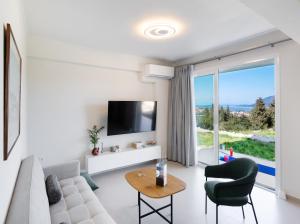 a living room with a couch and a tv at Asmira Apartments in Lygia
