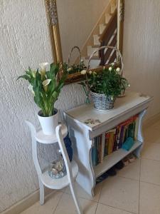 a table with flowers and a mirror and a chair at Apartment Josip in Risika