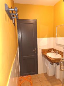 a bathroom with a black door and a sink at Studette du Logis du Parc in Libourne