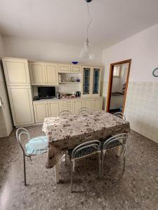 a kitchen with a table and two chairs and a table and a kitchen at Casa Vacanze da Francesco in Lettopalena