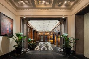 an ornate hallway with columns and plants in a building at Grand Hotel Terminus in Bergen