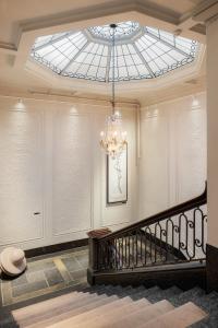 a staircase with a chandelier and a glass ceiling at Grand Hotel Terminus in Bergen