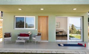 a house with a porch with a couch and chairs at Asmira Apartments in Lygia