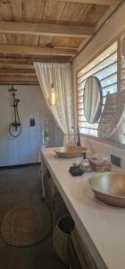 a bathroom with two sinks and a mirror on a counter at Lahima Cabanas Villa in Dickwella