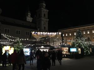 a group of people walking around a christmas market with lights at Next2Mozart-Apartment in Salzburg