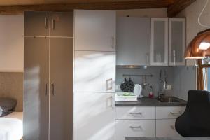 a kitchen with white cabinets and a sink at Il Giardino in Ilmmünster