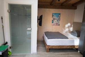 a bedroom with a bed and a glass door at Il Giardino in Ilmmünster