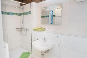 a white bathroom with a sink and a shower at Il Giardino in Ilmmünster