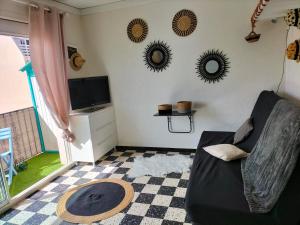 a living room with a couch and mirrors on the wall at studio centre plage in Canet-en-Roussillon