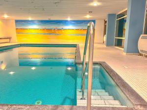 a swimming pool in a building with a painting on the wall at Haus Iderhoff- Wohnung 5 in Norderney