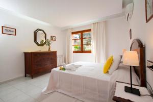 ein Schlafzimmer mit einem Bett, einer Kommode und einem Spiegel in der Unterkunft Villa Gotmar in Port de Pollença
