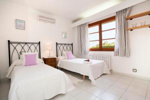 ein Schlafzimmer mit zwei Betten und einem Fenster in der Unterkunft Villa Gotmar in Port de Pollença