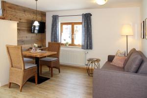 a living room with a table and a couch at Ferienwohnungen Vogler in Oberstdorf