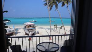 a balcony with a view of a beach with boats at Horizon Nest in Agatti