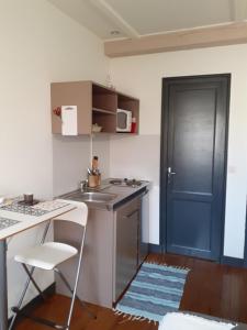 a small kitchen with a sink and a blue door at Studette du Logis du Parc in Libourne