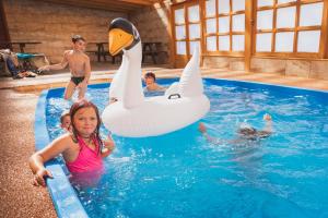 a young girl in a pool with a swan float at Chatová osada Budín u Žirovnice in Žirovnice