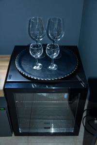 three wine glasses on a plate on a table at Αλώνι - Aloni in Angathiás